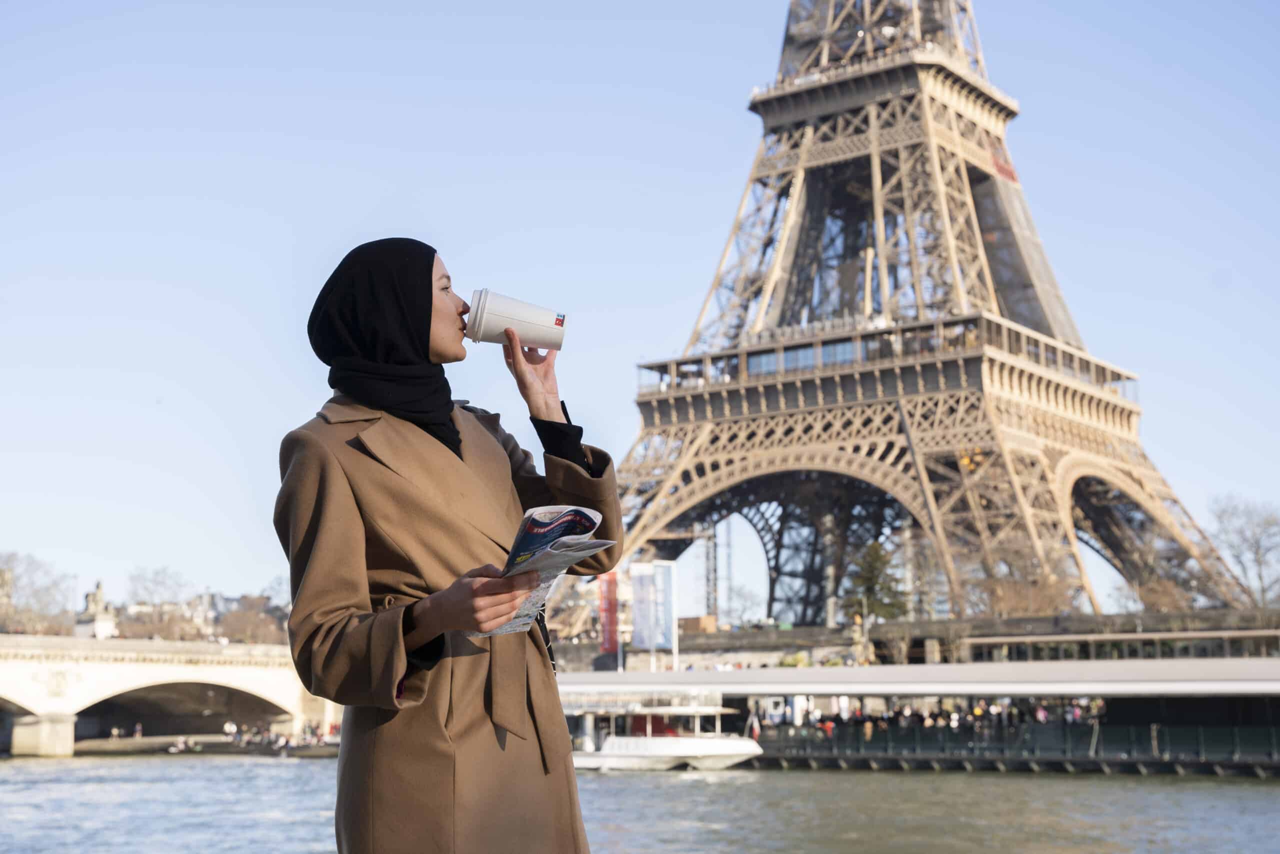 femme marocaine qui boit un café devant la tour eiffel